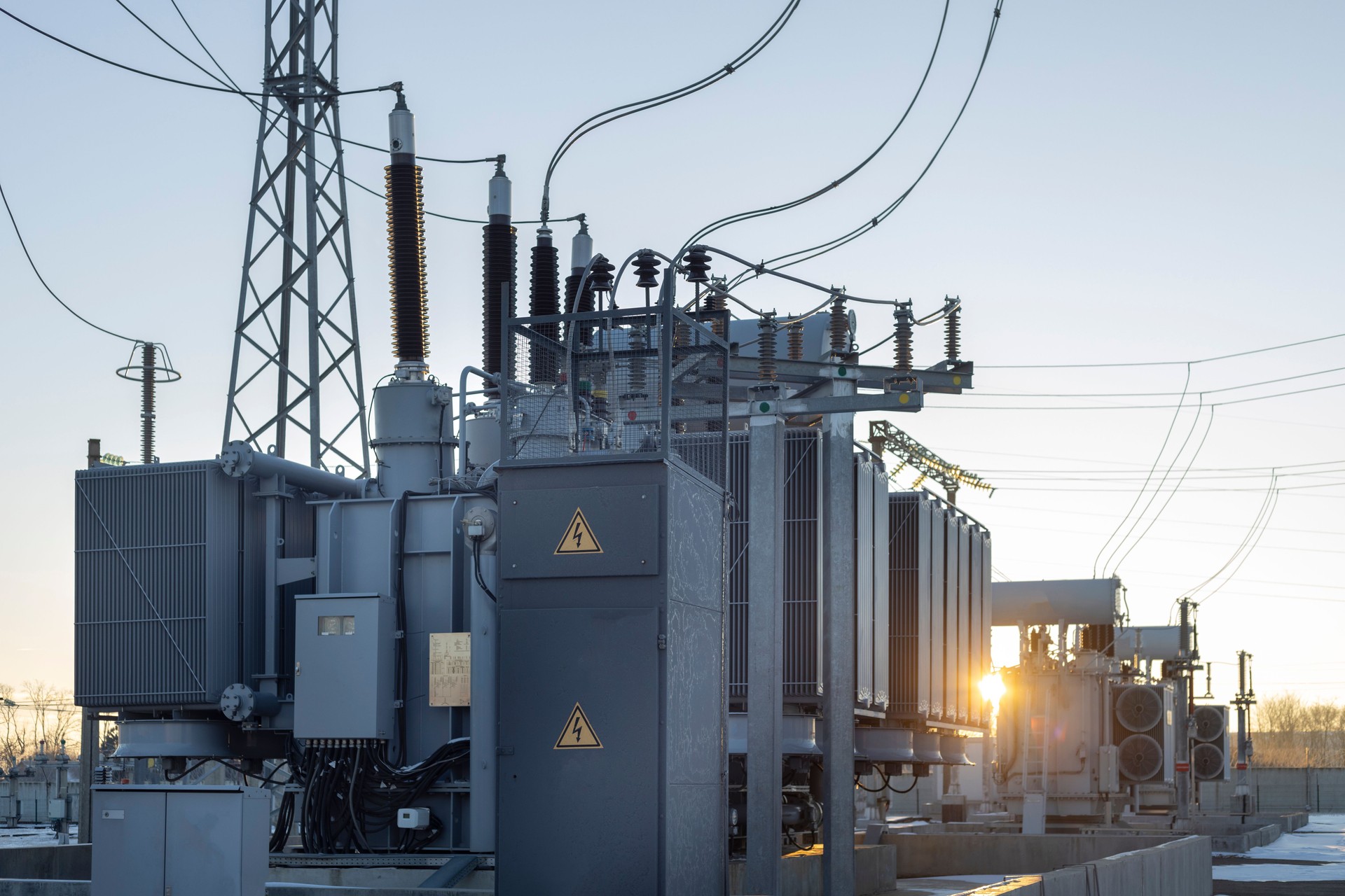 Power transformer at the substation with the rays of the morning sun. Energy. Cold winter dawn at the substation.